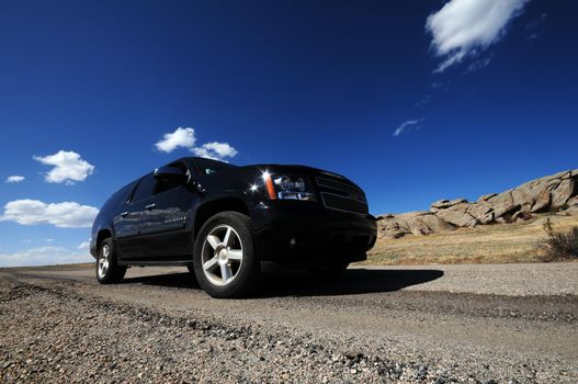 Large Black SUV on the Colorado Road. Wide Angle Photo. Summer Time in Colorado