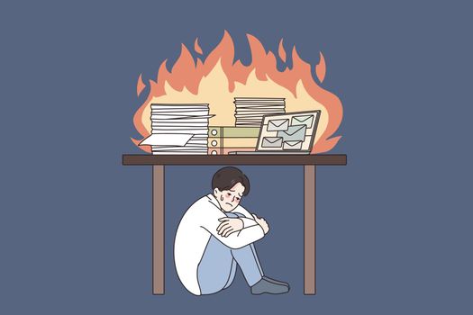 Unhappy man under desk stressed with work burnout