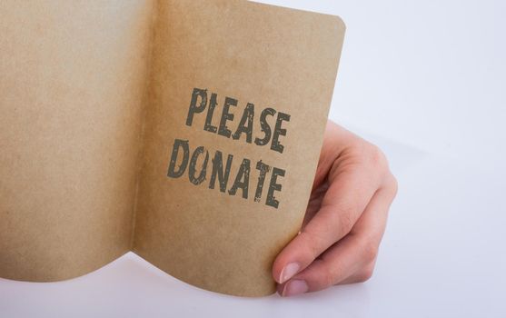 Hand holding a paper with please donate wording