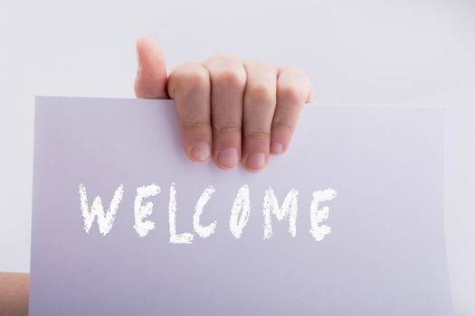 Hand holding paper with welcome wording