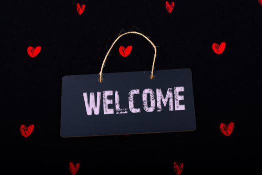 Welcome on black notice board  with red hearts around