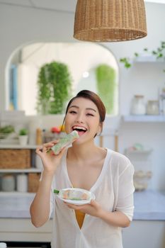 woman eating healthy spring roll 