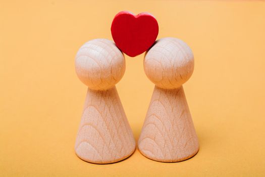 Heart shapes and wooden figurines of people as family concept 