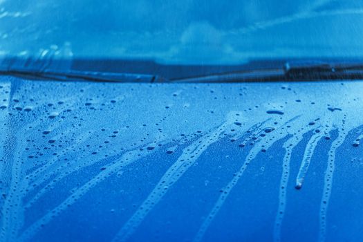 Close Image Of Wet Blue Passenger Car Hood And Windshield With Water Dripping Down. 