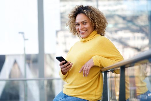 beautiful african american woman smiling with cellphone