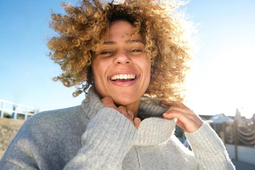 cheerful african american woman with curly hair laughing 