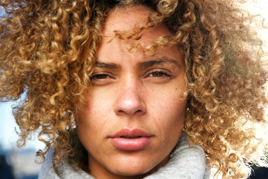 Close up beautiful african american woman with curly hair staring 