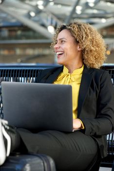happy businesswoman sitting with laptop computer