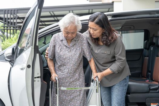 Help and support asian senior or elderly old lady woman patient walk with walker prepare get to her car, healthy strong medical concept.