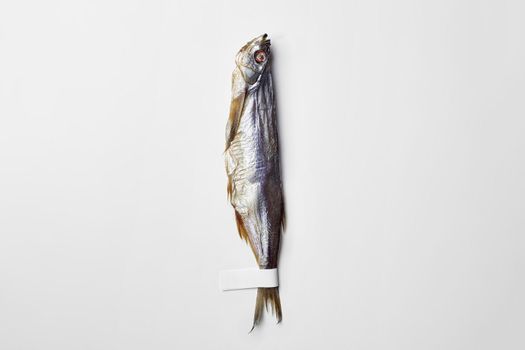 Salted air-dried sabrefish with paper label on tail isolated on white