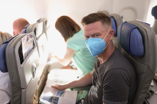 Couple flying on airplane, reading magazine to kill time