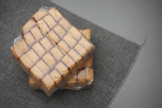 top view of sweet cookies in a plastic packet on wooden table