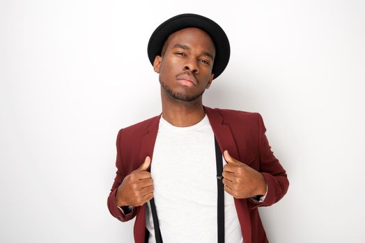 black male fashion model posing with hat and suspenders by white background