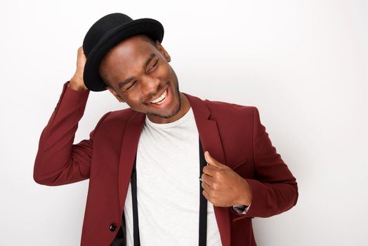 happy african american man posing with blazer and hat against white background
