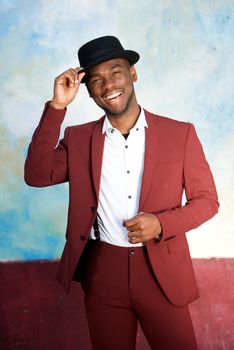 handsome young black man smiling with hat and vintage suit