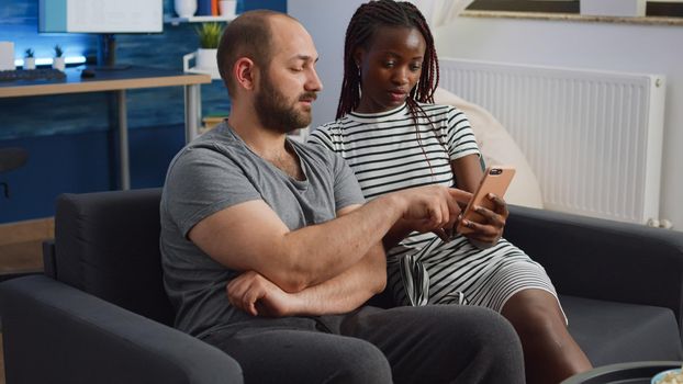 Young interracial couple looking at smartphone