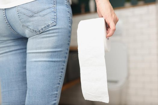 Woman hold toilet paper roll in hands, came to toilet room