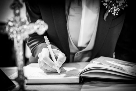 wedding best man groom signing register in catholic wedding