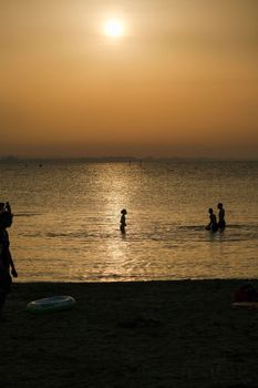 Rimini beach at sunset with yellow sky Riviera Romagnola People silouette