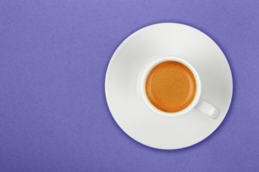 Full white espresso coffee cup on purple
