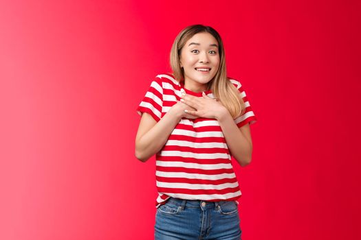 Impressed tender asian silly blond girl amazed describe fascinating performance, woman press palms chest smiling speechless adore cool gift, feed grateful and appreciation, stand red background