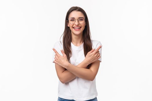 Waist-up portrait of enthusiastic smiling young brunette woman in glasses and casual t-shirt give advice where find all you need, laughing friendly looking camera, pointing left and right