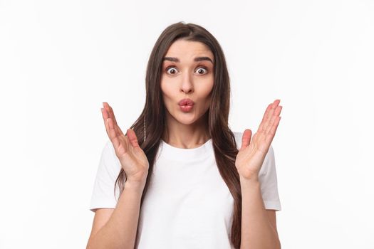 Portrait of happy surprised young woman glad hear friend getting promoted, clasp hands in congratulations, folding lips astonished and excited, smiling stand white background
