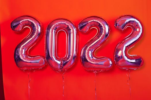 Foil balloons numeral 2022 Happy New Year Festive red background