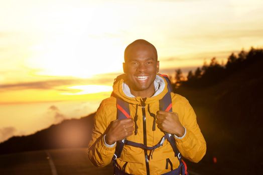 happy african american hiker with backpack during sunset 