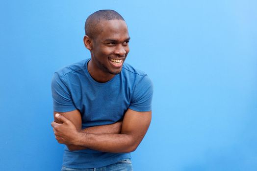 handsome young black man laughing with arms crossed
