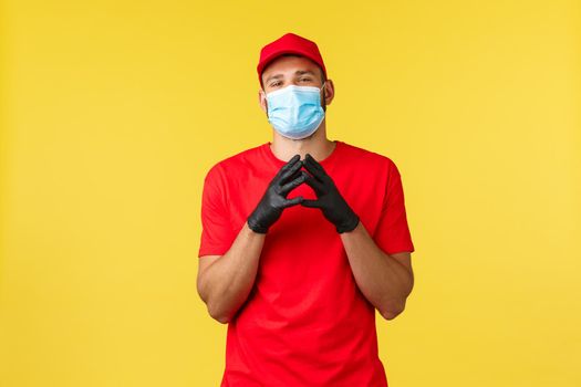 Express delivery during pandemic, covid-19, safe shipping, online shopping concept. Smart and creative courier in red uniform, gloves and medical mask, scheming, steeple fingers sly