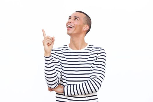happy young man pointing finger up against isolated white background