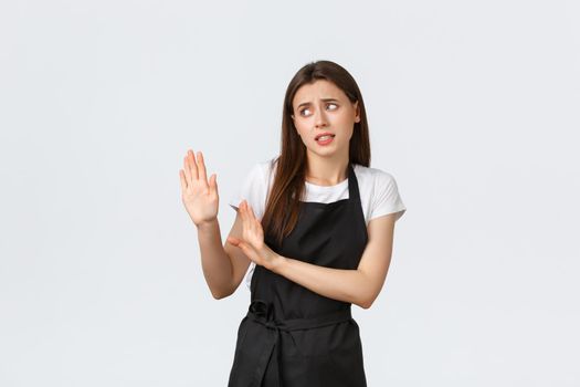 Grocery store employees, small business and coffee shops concept. Disgusted and reluctant barista avoiding strange guest. Displeased saleswoman raising hands defensive in rejection