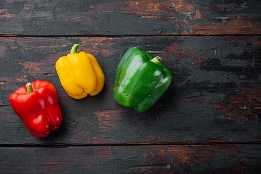 Green , yellow and red bell pepper, on old dark wooden table background, top view flat lay with copy space for text