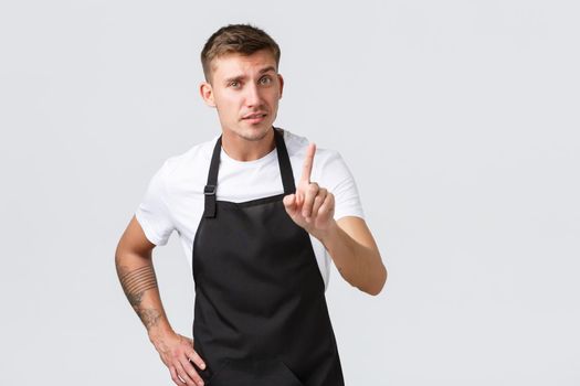 Employees, grocery stores and coffee shop concept. Serious-looking handsome barista teaching lesson how brew coffee home, shaking finger as scolding, prohibit or forbid something