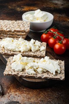 Crisp bread with cream cheese, on old dark rustic table background
