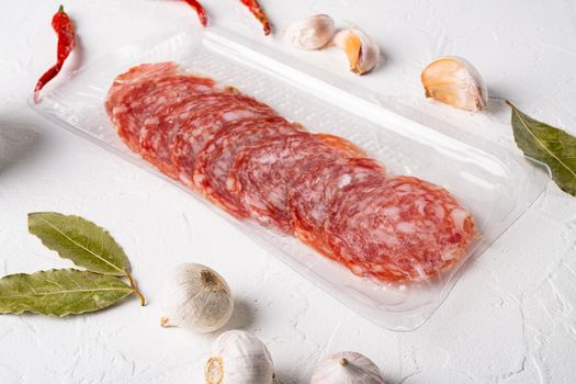 Tray Packaged of sliced air cured pork meat, on white stone table background