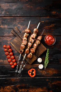 Grilled meat skewers, shish kebab with onion, on old dark wooden table background, top view flat lay, with copy space for text