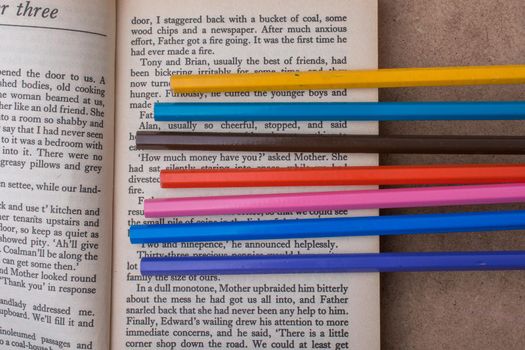 Color pencils placed on the page of a book