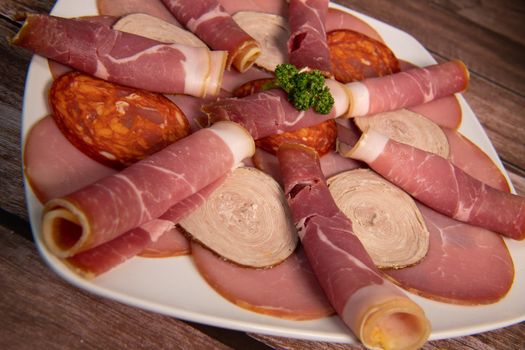 Food tray with delicious salami, pieces of sliced ham, sausage, Deli meats, Pickles