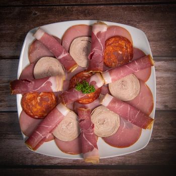 Food tray with delicious salami, pieces of sliced ham, sausage, Deli meats, Pickles