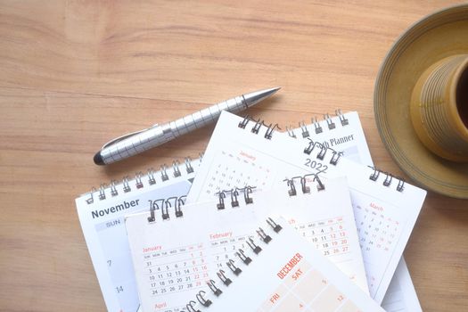 tack of calendar and cup of tea on table