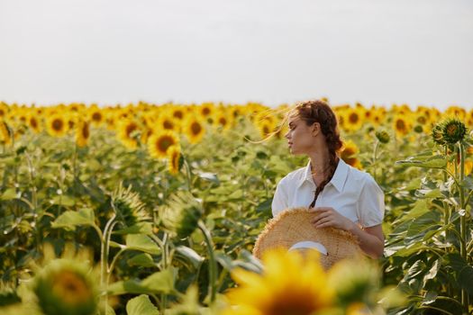 beautiful sweet girl in a hat on a field of sunflowers countryside. High quality photo