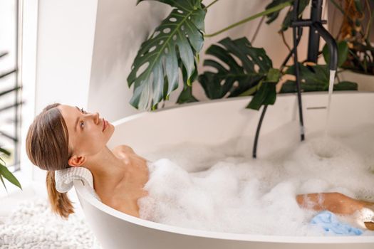 Relaxed young woman bathing while spending time indoors at luxury spa resort