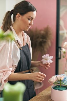 Professional florist young woman is doing bouquets at flower shop