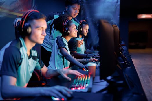 Young gamers in headsets playing in video game club