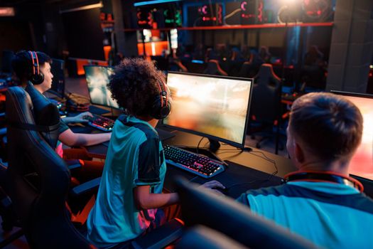 Esports team playing online game on computers in gaming club