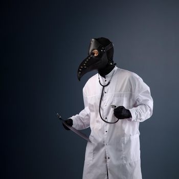 a doctor in a dressing gown wearing a plague doctor mask with a stethoscope in his hands