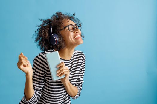 Cheerful woman listening to music on smartphone