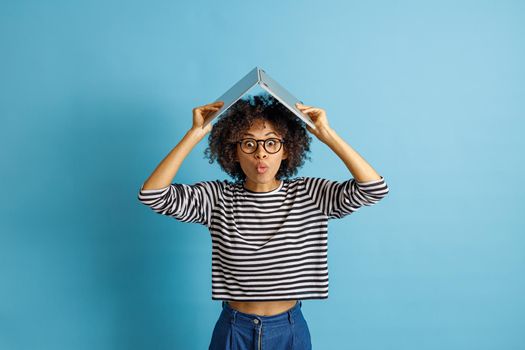 Multiracial woman holding laptop above her head